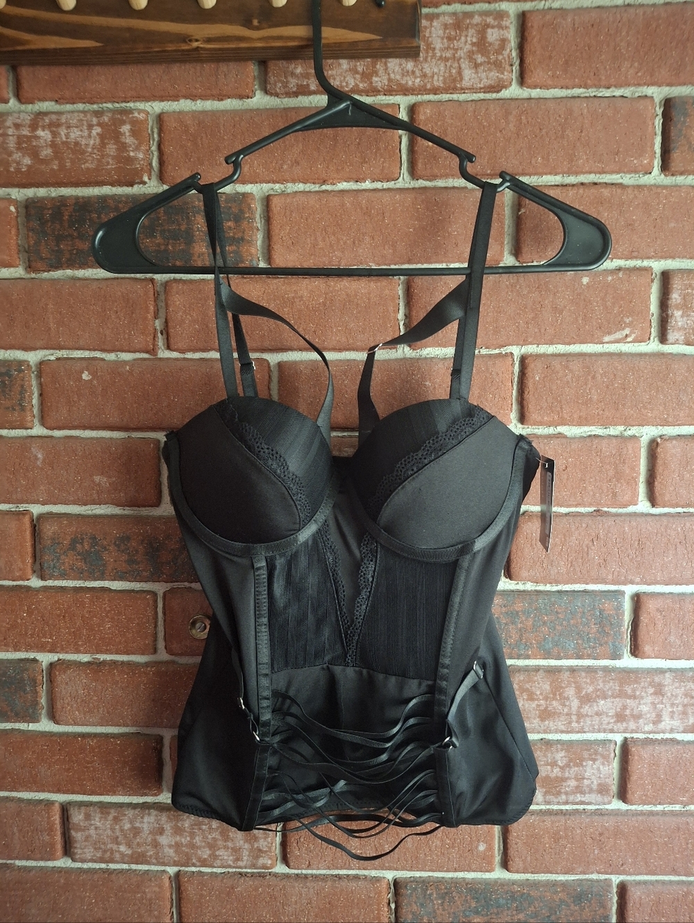 Black corset top with lace detailing and adjustable straps
